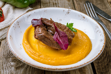 Beef cheeks with mashed potatoes on wooden background