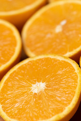 Orange background. Closeup of half cut fruits
