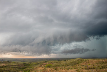A wall cloud gathers under the base of a supercell storm in the great plains.