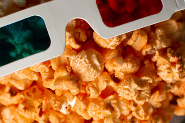 3d paper glasses and cheesy popcorn close up