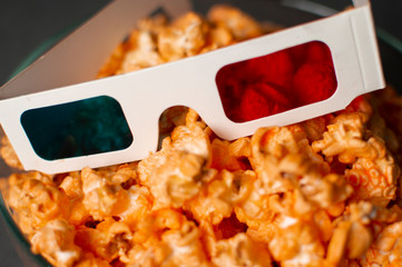 3d paper glasses and cheesy popcorn close up