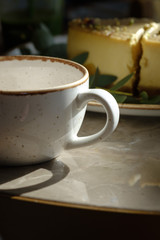 Mug for tea, against the background of a dessert cheesecake