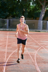 Obraz premium Young muscular man running on the track