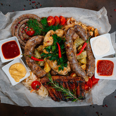 Meat sausages with pork ribs, potatoes, cabbage and cherry tomatoes