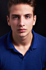 Elegant young handsome man posing on black background