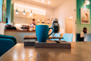 Hot cappuccino coffee in coffee shop on wooden table
