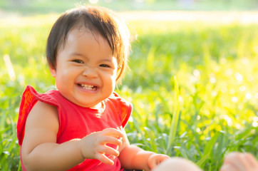 Portrait face of cute asian little girl and child happiness and fun in the park in the summer, smile and happy from asia kid and relax in the garden, lifestyle childhood concept.