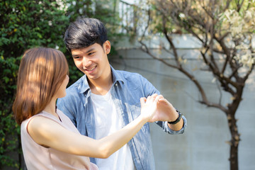 Beautiful happy young couple fun making gesture heart shape with hand outdoor together, man and...