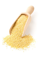 Pile of golden millet, a gluten free grain seed, in wooden scoop over white