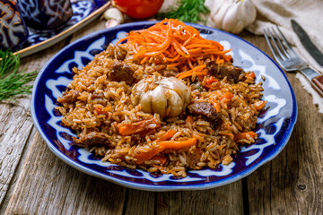 pilaf with beef on wooden background