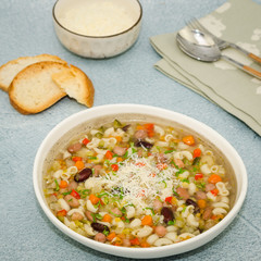 Minestrone soup. Vegetables soup served with parmesan and croutons, rustic background. 
