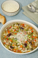 Minestrone soup. Vegetables soup served with parmesan and croutons, rustic background. 