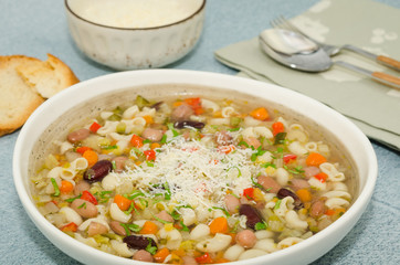 Minestrone soup. Vegetables soup served with parmesan and croutons, rustic background. 