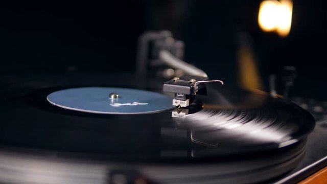 A record is rotating under the turntable needle