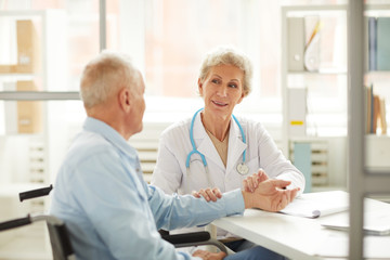 Obraz premium Portrait of female doctor checking pulse while consulting elderly man, copy space