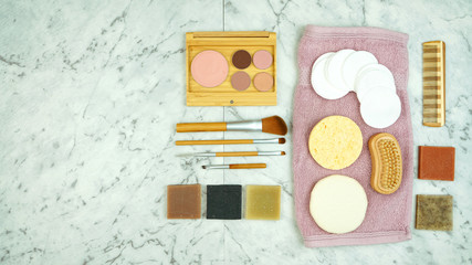 Zero-waste, plastic-free beauty and makeup flatlay overhead with coconut fiber, bamboo and reusable products.