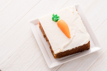 Carrot cake slice with frosting carrot topper