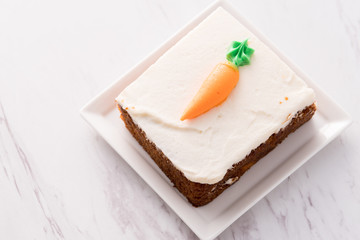 Carrot cake slice with frosting carrot topper