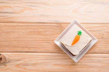 Carrot cake slice with frosting carrot topper