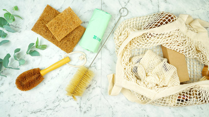 Zero-waste, plastic-free household flatlay overhead with coconut fiber, bamboo and reusable laundry and eco-friendly cleaning products.