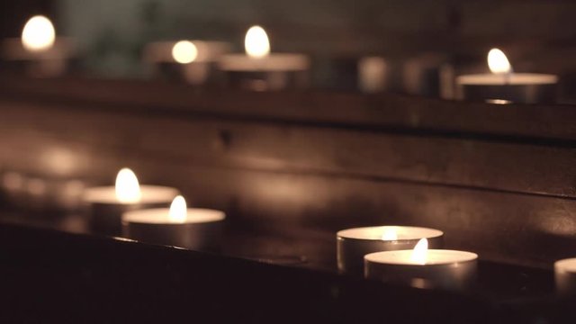 changing the focus from the candles at the top of the table, to the candles at the bottom of the church table for candles.without color correction, close-up.