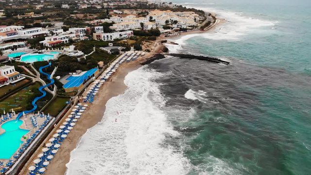 Drone Aerial of Anissaras Coastline Near Hersonissos on Famous Historic Crete Island Greece With Hotel Pools Beaches and Mediterranean Sea Waves 4k