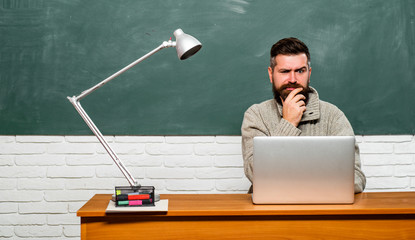 Back to school and Education concept. Student sitting at table and writing on notebook. Back to school. Bearded teacher.