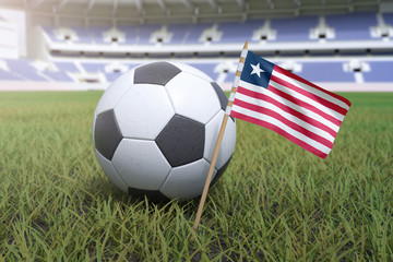 Liberian flag in stadium field with soccer football
