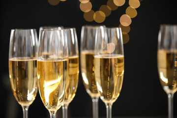 Glasses of champagne on blurred background, closeup. Space for text