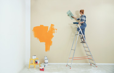 Woman painting wall indoors, space for text. Home repair