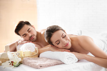 Young couple with spa essentials in wellness center
