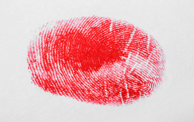 Red fingerprint on white background. Friction ridge pattern