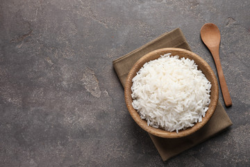 Bowl of delicious cooked rice served on table, flat lay. Space for text