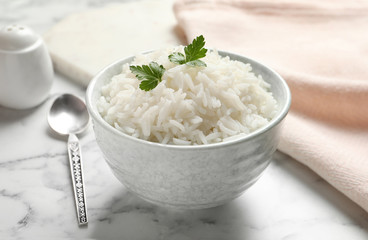 Bowl of tasty cooked rice with parsley served on table