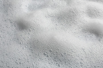 Soft white soap foam as background, closeup