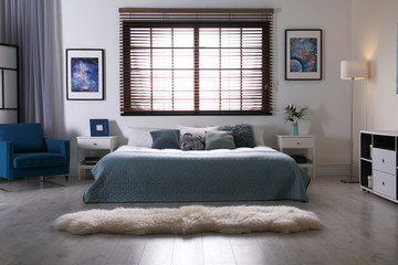 Modern room interior with comfortable double bed and window blinds - obrazy, fototapety, plakaty