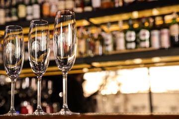 Empty clean champagne glasses on counter in bar. Space for text