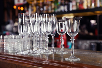 Different empty clean glasses on counter in bar