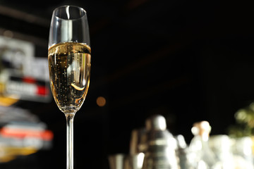Glass of champagne in bar, low angle view. Space for text