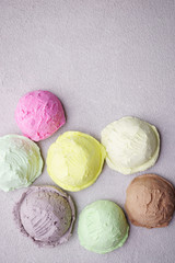 Set of ice cream scoops of different colors and flavors  on stone table, copy space. Food background, summer refreshing concept, traditional seasonal cold sweets