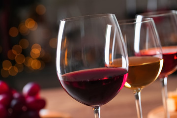 Glasses with different wines against blurred background, closeup