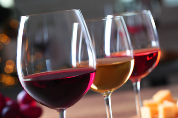 Glasses with different wines on blurred background, closeup