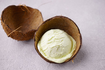 Coconut ice-cream scoop in coco shell. Summer background, tropical vacation concept, delicious...