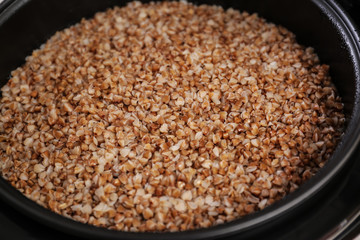 Delicious hot buckwheat in modern multi cooker, closeup