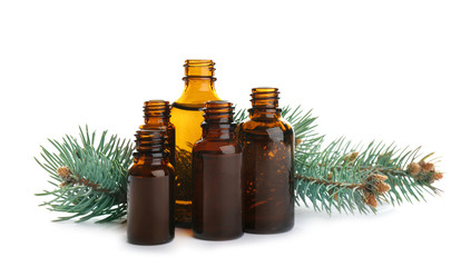 Different little bottles with essential oils and pine branches on white background