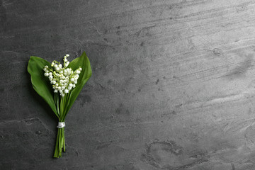 Beautiful lily of the valley bouquet on grey background, top view. Space for text