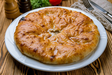Ossetian pie with meat on white plate