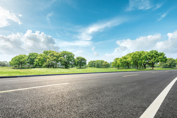 Country road and green forest natural landscape under the blue sky - obrazy, fototapety, plakaty