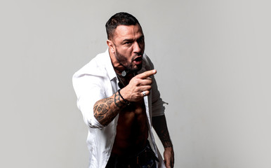 Anger concept. Aggressive man shout with anger. Guy tense face shouting pointing finger forward....