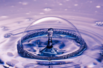 Gota de agua traspasando una burbuja de jabón.